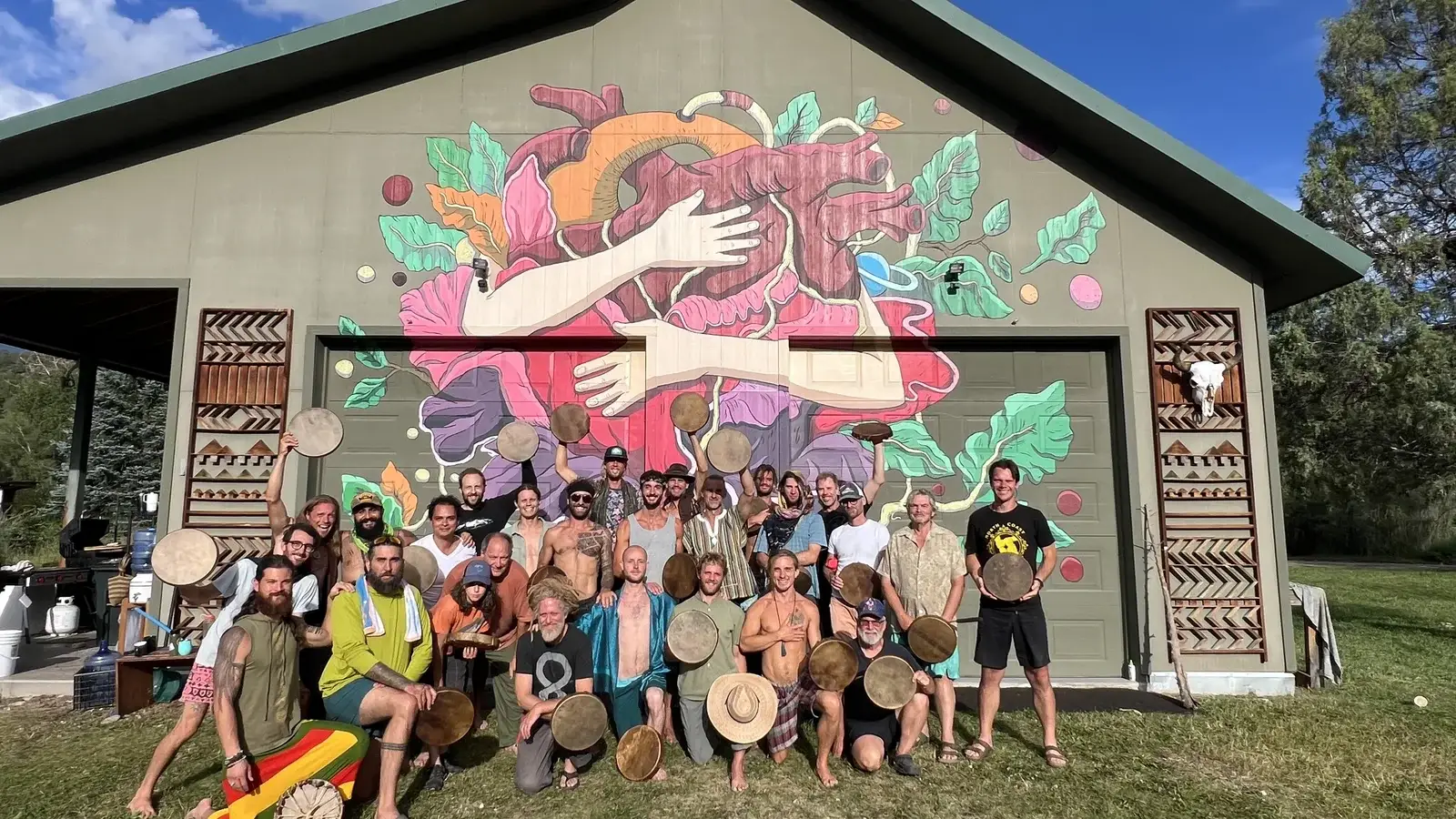 Mountain Heart 2024 cohort in front of the retreat barn mural